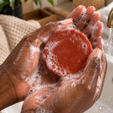 Savon naturel à la carotte, au curcuma et à la papaye utilisé dans des mains africaines
